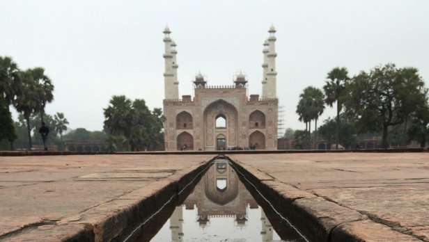 The gate at Emperor Akbar’s tomb is reflected in the channel pool of water.